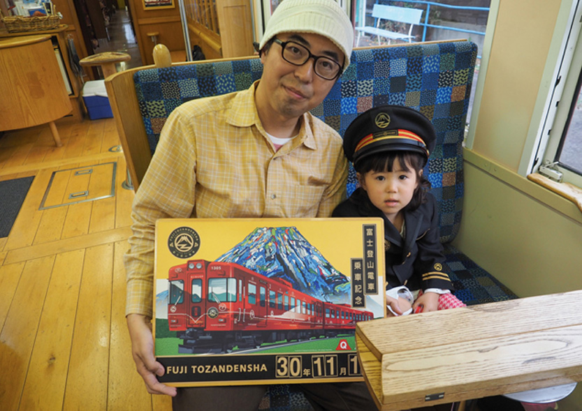親子で鉄道の記念プレートを持った写真