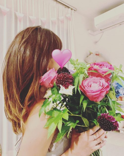 Photo of mom covering her face with a bouquet of flowers.