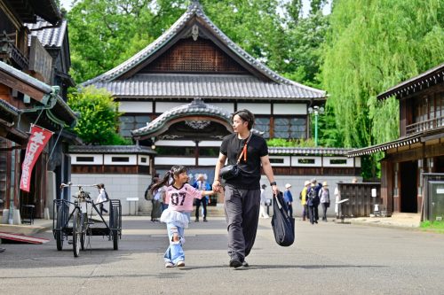 A photo of a dad and his child walking through the Edo-Tokyo Open-Air Architectural Museum