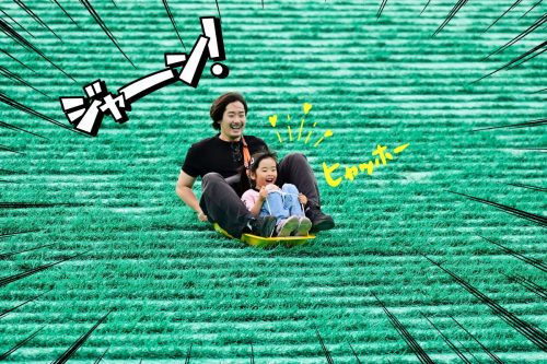 A photo of a dad and his child enjoying sledding