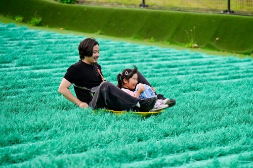 A photo of a dad and his child enjoying sledding