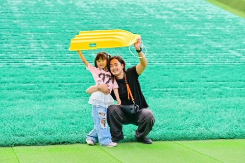 A photo of a dad and his child enjoying sledding