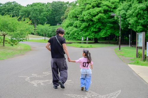 A photo of a dad and his child walking hand in hand in Koganei Park